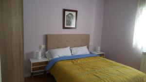 a bedroom with a bed with a blue and yellow blanket at Apartamento en Avenida Quevedo in León