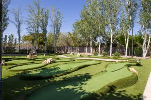 a lush green golf course with trees in the background at Tamarit Beach Resort in Tamarit