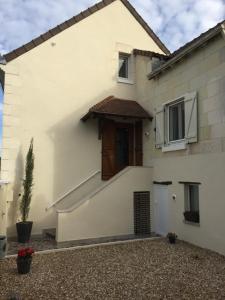 Casa blanca con puerta marrón en Le Petit Nid de Beauval en Saint-Aignan