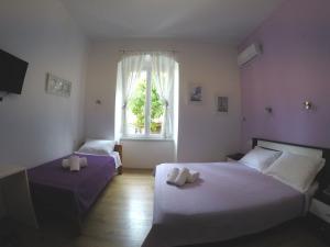 1 dormitorio con 2 camas y ventana en Rooms Gero, en Zadar