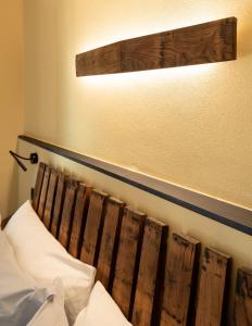 a bed with a wooden headboard and a light above it at Meb in Riomaggiore