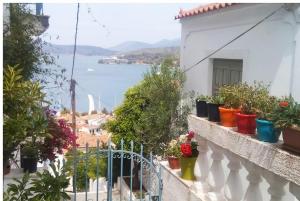 a balcony with potted plants and a view of the water at CENTRAL TOWN STUDIO ON POROS in Poros