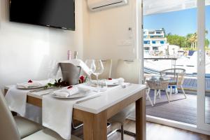 ein Esszimmer mit einem weißen Tisch und einem Balkon in der Unterkunft Portoverde Luxury Houseboat in Misano Adriatico