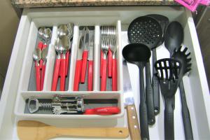 a white drawer filled with utensils and spatulas at BsAs Platino Apart in Buenos Aires
