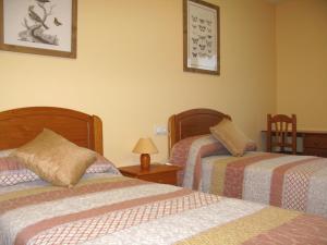 1 dormitorio con 2 camas y mesa con lámpara en Apartamento Punta Gábalo, en Broto
