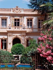 une vieille maison avec des fleurs devant elle dans l'établissement Le Roussillon, à Amélie-les-Bains-Palalda
