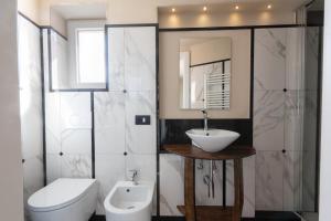 a bathroom with a sink and a toilet and a mirror at Meb in Riomaggiore