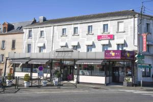 a large white building on the corner of a street at Hotel l'Europe - Cholet Gare in Cholet