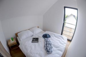 a bedroom with a bed with a book and a window at Amber Playa in Dębki
