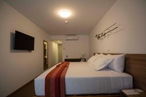 a hotel room with a bed with a television on the wall at Tierra Viva Miraflores Centro in Lima