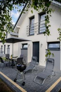 a group of chairs and a grill in front of a house at Amber Playa in Dębki