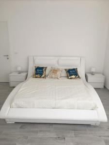 a large white bed with pillows and two tables at Roof Top 19 in Ventimiglia