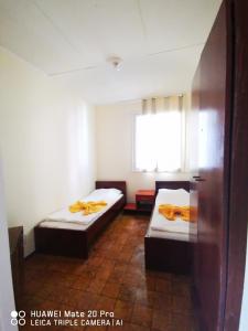 mały pokój z 2 łóżkami i oknem w obiekcie Letovishte Romantika w Kamcziji