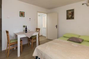a bedroom with a table and a bed and a table and chairs at Apartment Meet & Greet in Dubrovnik