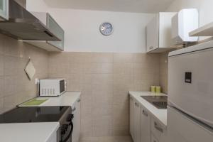 a small kitchen with white cabinets and a microwave at Apartment Meet & Greet in Dubrovnik