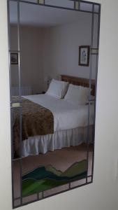 a bedroom with a large bed in a mirror at Achintee Farm Guest House in Fort William