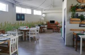 une salle à manger avec des tables, des chaises et une télévision dans l'établissement La Cordata Accommodation - Hotel Woodhouse, à Cinisello Balsamo