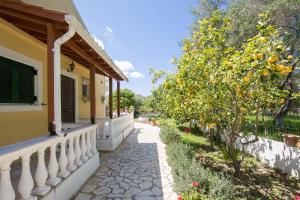 
a garden area with a patio and a tree at Karia Holiday Home in Lefkimmi
