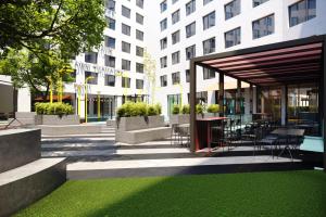 un patio con mesa y sillas y un edificio en The Social Hub Berlin Alexanderplatz en Berlín