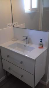 een badkamer met een witte wastafel en een spiegel bij Studio in La Trinité-sur-Mer