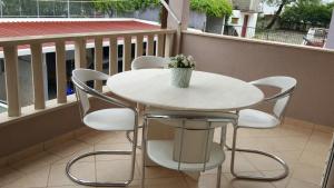 a white table and chairs on a balcony at Apartments Ruzica in Makarska +26 photos