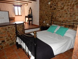 a bedroom with a bed in a brick wall at Casa del Limonero in Guaro