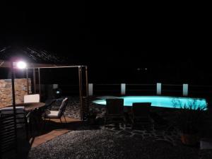 una piscina por la noche con mesa y sillas en Casa del Limonero en Guaro