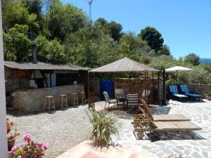 eine Terrasse mit Tisch und Stühlen und einem Sonnenschirm in der Unterkunft Casa del Limonero in Guaro
