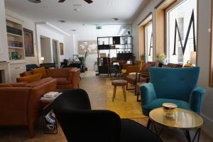 a living room with couches and chairs at Hotel Boutique OMA in Sant Feliu de Guíxols