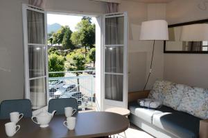 - un salon avec un canapé, une table et une fenêtre dans l'établissement La Résidence des Thermes, à Bagnères-de-Bigorre