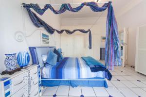 a blue and white bedroom with a bed and curtains at A Heavenly View in Muizenberg