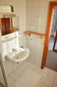 a white bathroom with a sink and a mirror at Haus Oswald am See in Hermagor