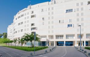 een wit gebouw met een straat ervoor bij Sky & Sun Luxury Rooms with private parking in the garage in Zadar