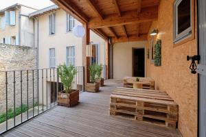 a wooden deck with benches on a building at Mélina - appartement dans les remparts de la Bastide avec parking et terrasse in Carcassonne