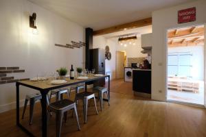 een keuken en eetkamer met een tafel en stoelen bij Mélina - appartement dans les remparts de la Bastide avec parking et terrasse in Carcassonne