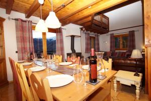 a wooden table with wine bottles and glasses on it at Chalet du Pre in Séez