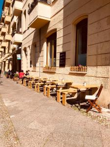 una fila de mesas de madera frente a un edificio en Pension Kaffeefreunde en Berlín