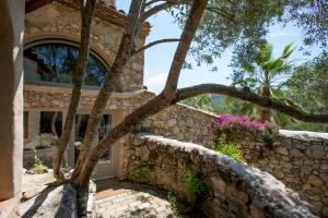 una casa de piedra con un árbol delante en Casa Olivo at Masia Nur Sitges, Adults only, en Canyelles