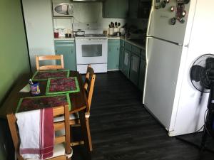 a kitchen with a table and a white refrigerator at Ranny's Private Rooms in Calgary