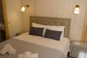 a bedroom with a large bed with two pillows at Casa do Rabana in Leiria