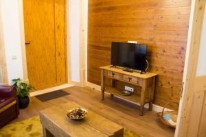 a living room with a tv on a wooden wall at Casa do Rabana in Leiria