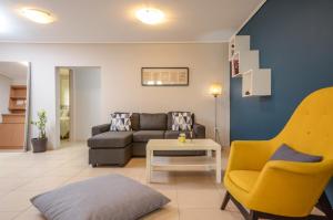 a living room with a couch and a table and chairs at Boutique Apartments in Athens in Athens