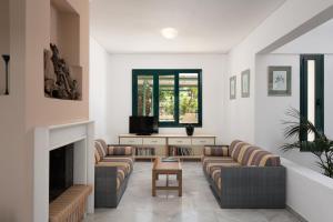 a living room with couches and a fireplace at Aris Villa in Panormos Rethymno