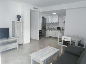 a living room with a couch and a table and a kitchen at Apartamentos Cachón in Zahara de los Atunes