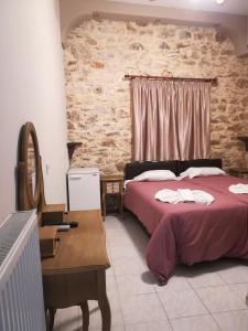 a bedroom with a bed and a table with a mirror at Skourtaniotis spa rooms in Loutra Edipsou