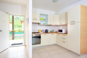 a kitchen with white cabinets and a window at Appartamento Benji1 in Nago-Torbole