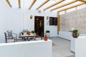 een patio met een tafel en stoelen en een bakstenen muur bij Casa Kariki - Traditional House in Psinthos in Psinthos