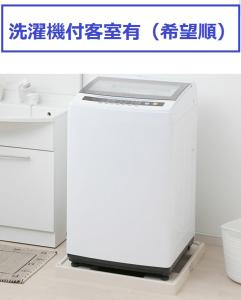 a white refrigerator in a room with a sign at Nice Hostel Kameari in Tokyo