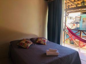 1 cama con 2 almohadas y ventana en Pousada Porto do Sol en Ilha Grande