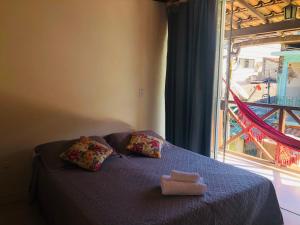 un letto con due cuscini e una finestra di Porto do Sol Suítes a Abraão